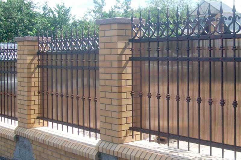 Сварной кованый забор на кирпичных столбах с элементами поликарбоната